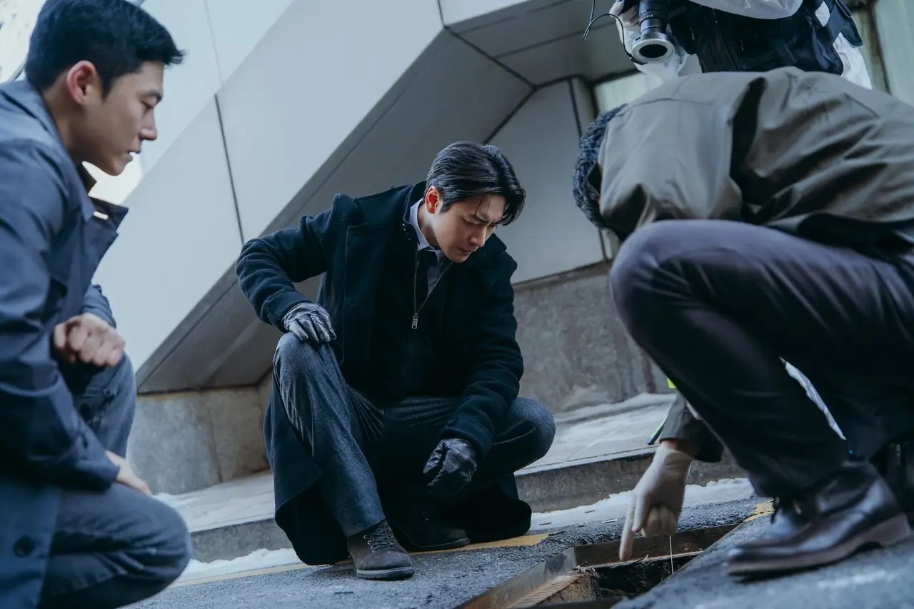 하수구 아래 시신을 바라보는 경찰들