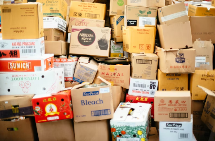 다양한 상표의 택배 박스들이 무질서하게 쌓여 있는 모습. 명절이나 특수기간의 물류 혼잡을 보여주는 이미지.