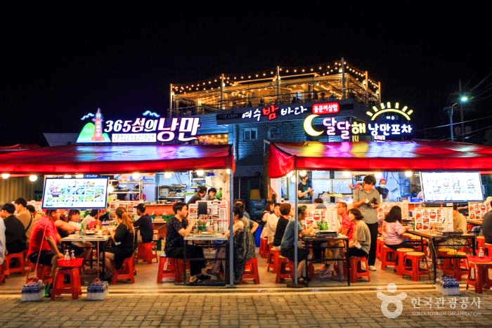 사람들이 포차앞에서 식사를 하고 있다.