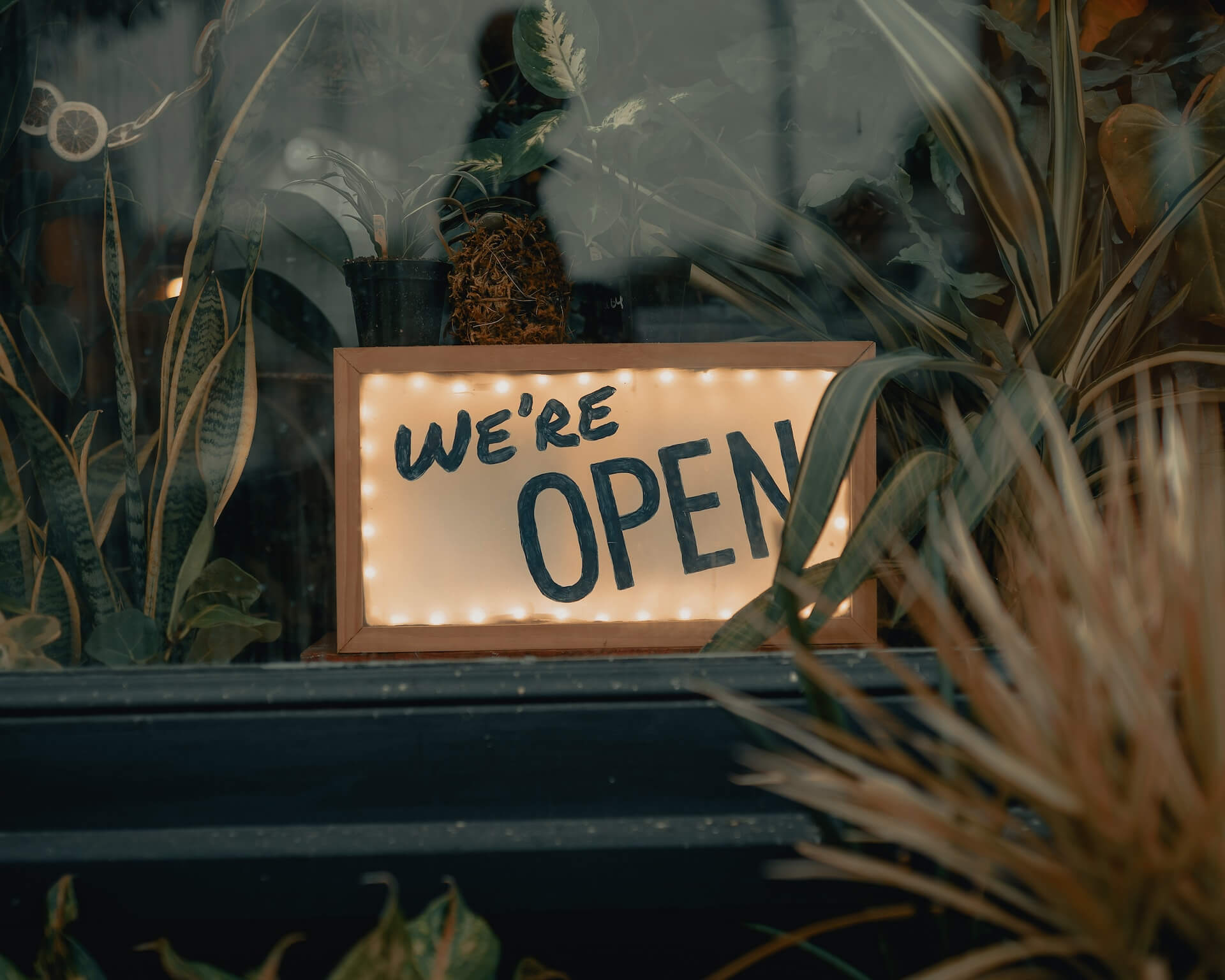 An opening sign is on a window of an unmanned shop.