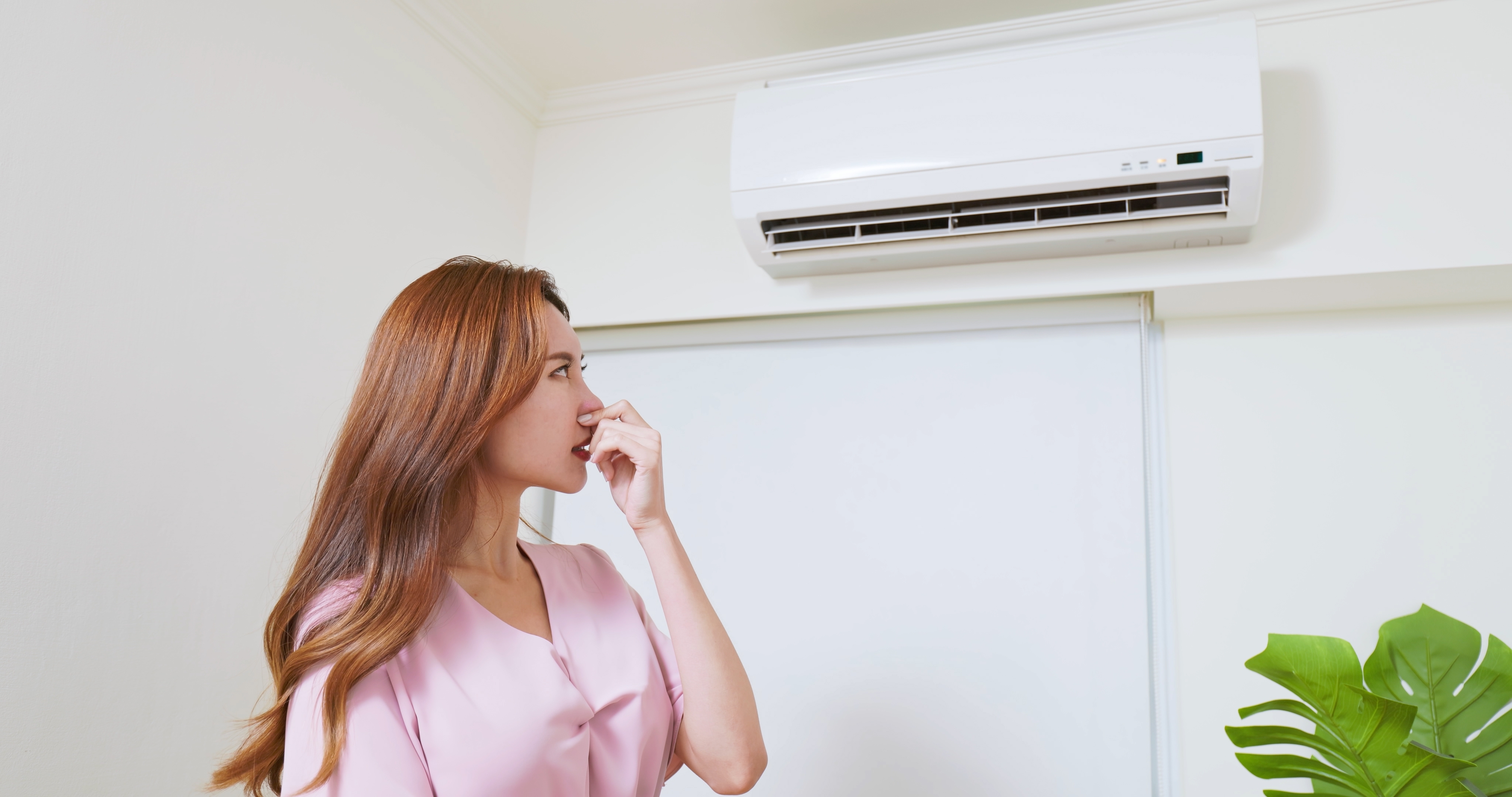 여름철 에어컨 냄새를 맡고 불쾌해하는 여성의 모습, 실내 악취의 원인을 설명하는 이미지