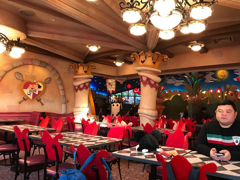 노란색 불빛의 조명들이 천장에 있고 밑으로 테이블들이 배치되어 있다.