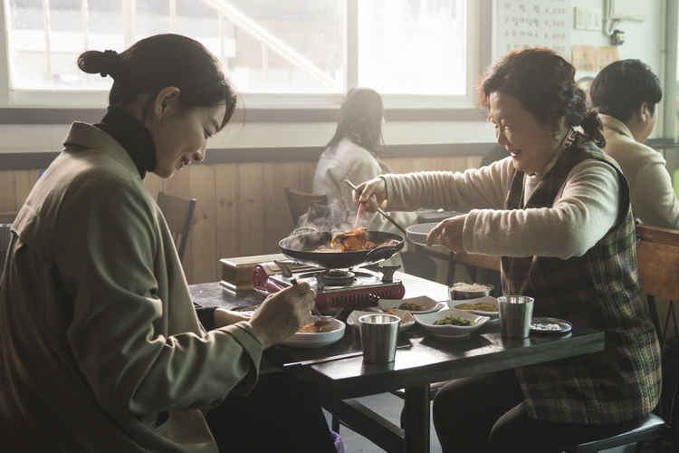 두 여자가 식당에서 음식을 먹고 있다. 모녀이다.