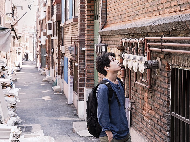 주택 위를 바라보는 남성의 모습