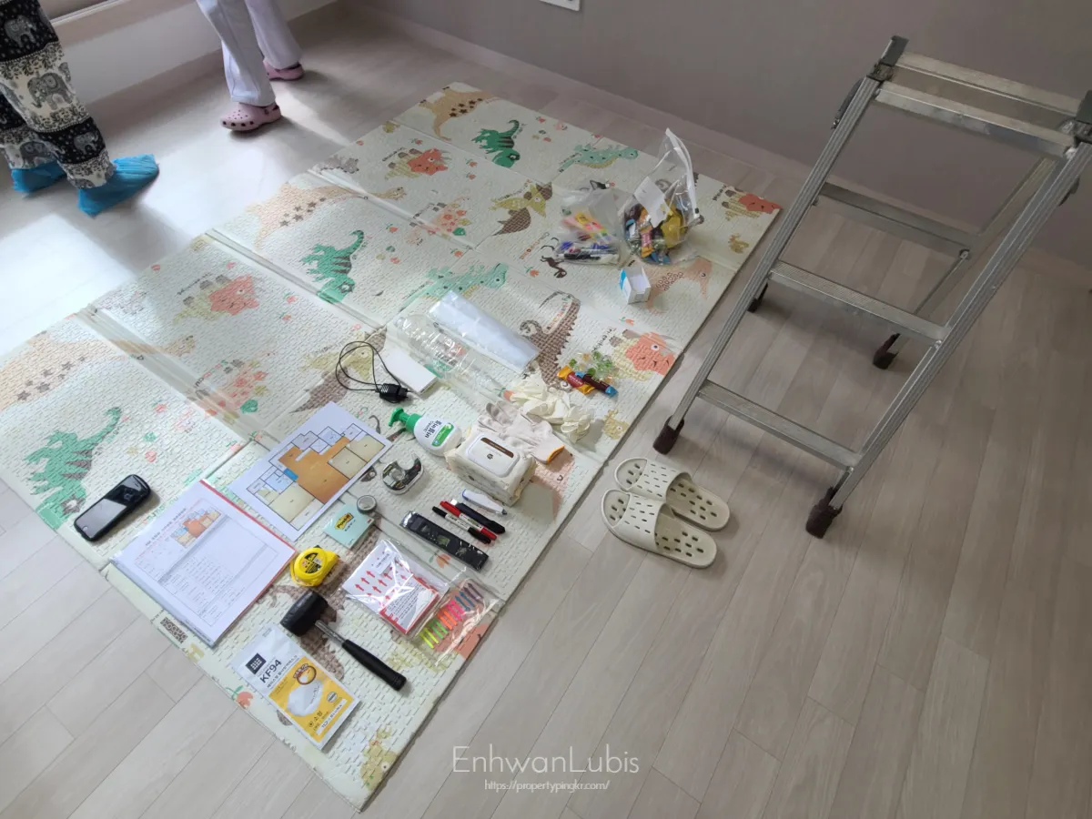 돗자리-위에-여러개의-사전점검준비물이-놓여있는-그옆에-미니사다리-실내화가-있는