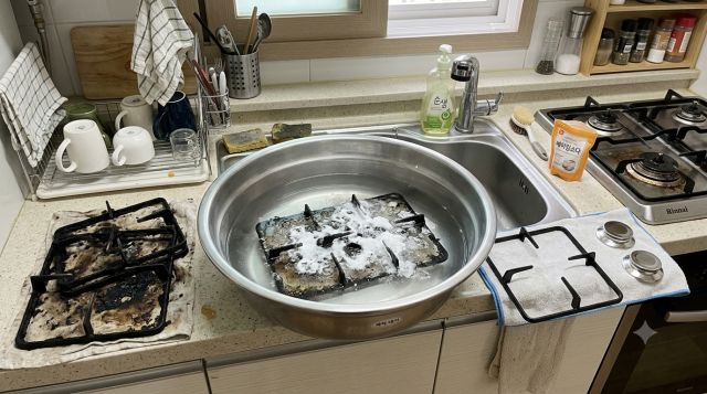 베이킹소다와 따뜻한 물에 담가 찌든 기름때를 불리고 있는 가스레인지 삼발이