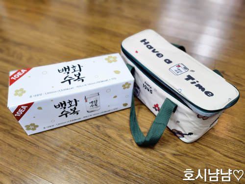 트레이더스에서 구매한 백화수복 원컵 10입 패키지와 귀여운 디자인의 아이스백이 바닥에 함께 놓여 있는 모습