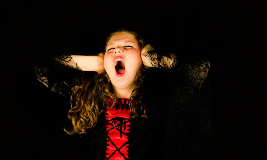 손으로 귀를 맊고 입을 벌리면서 소리를 지르고 있는 소녀