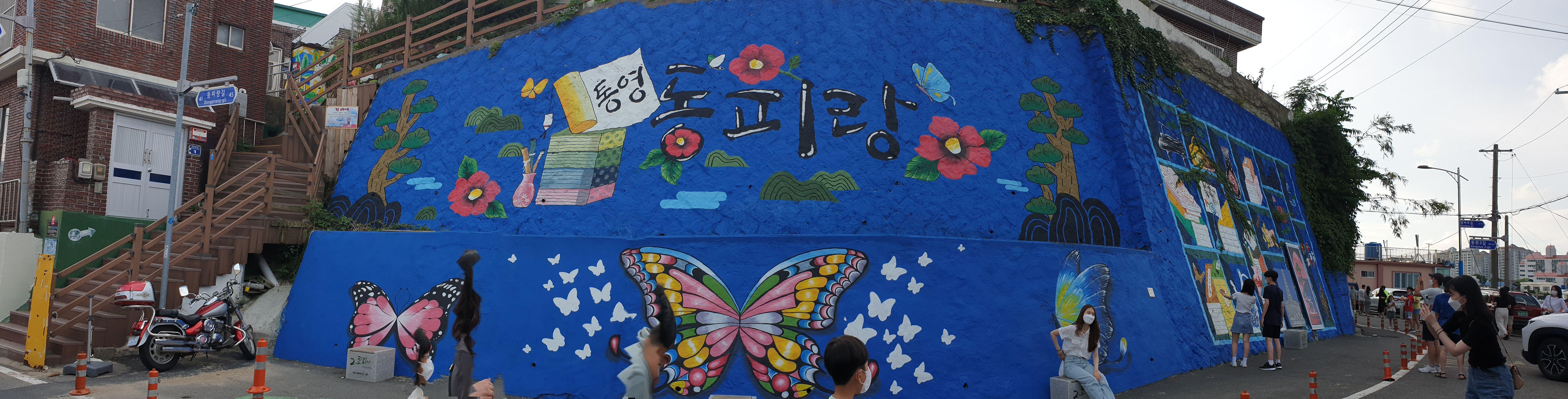 벽에 파란페인트를 칠한뒤 나비, 동백꽃등을 그림