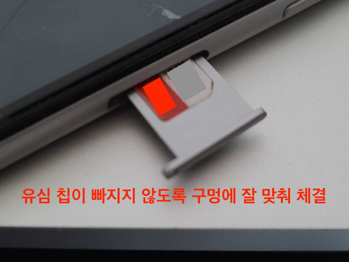 유심칩이 장착된 유심 트레이를 스마트폰에 삽입하는 모습