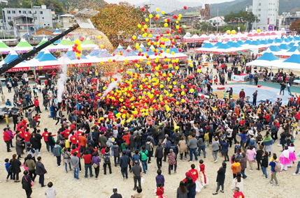 축제장의 인파 위로 풍선이 날리는 모습