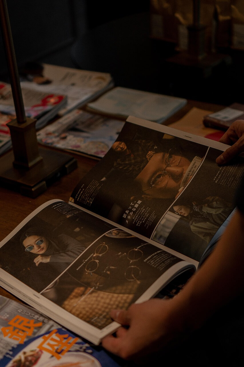 넓은 가판대 위에 다양한 책들이 놓여 있고 누군가 책을 손으로 잡고 있다