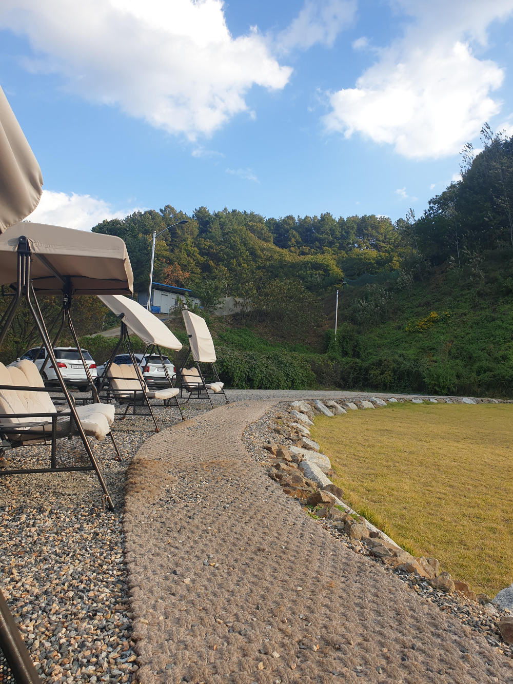 흔들 의자가 원형으로 배치되어 있다. 햇빛을 가릴 수 있게 처마가 조절된다.