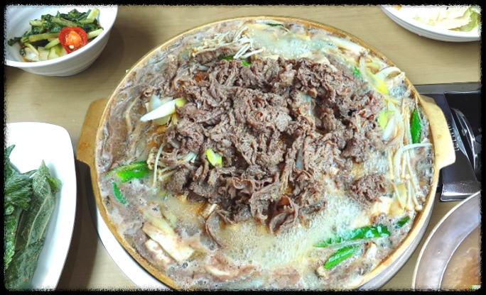 황동 불판 위에서 각종 버섯, 야채와 함께 지글지글 끓고 있는 대전 함흥냉면 맛집의 야들야들한 한우 양념 불고기