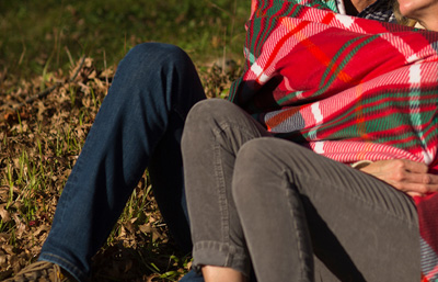 잔디밭에 누워 담요를 덮고 있는 남녀.