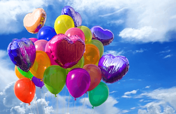 파란 하늘에 풍선들이 가득 떠 있다. 분홍색, 보라색, 노란색, 주황색, 연두색 풍선들이다.
