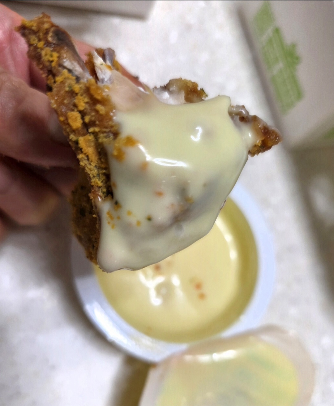 BHC 커링클 치킨을 크리미한 소스에 찍어 먹는 모습