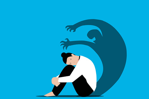 몸을 웅크리고 있는 여성과 그림자
