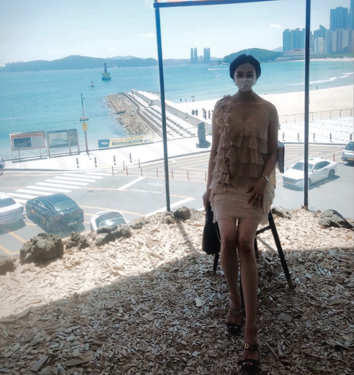 부산 해운대 바닷가 풍경을 배경으로 찍은 전신 사진&#44; 도심과 바다가 어우러진 카페 전경