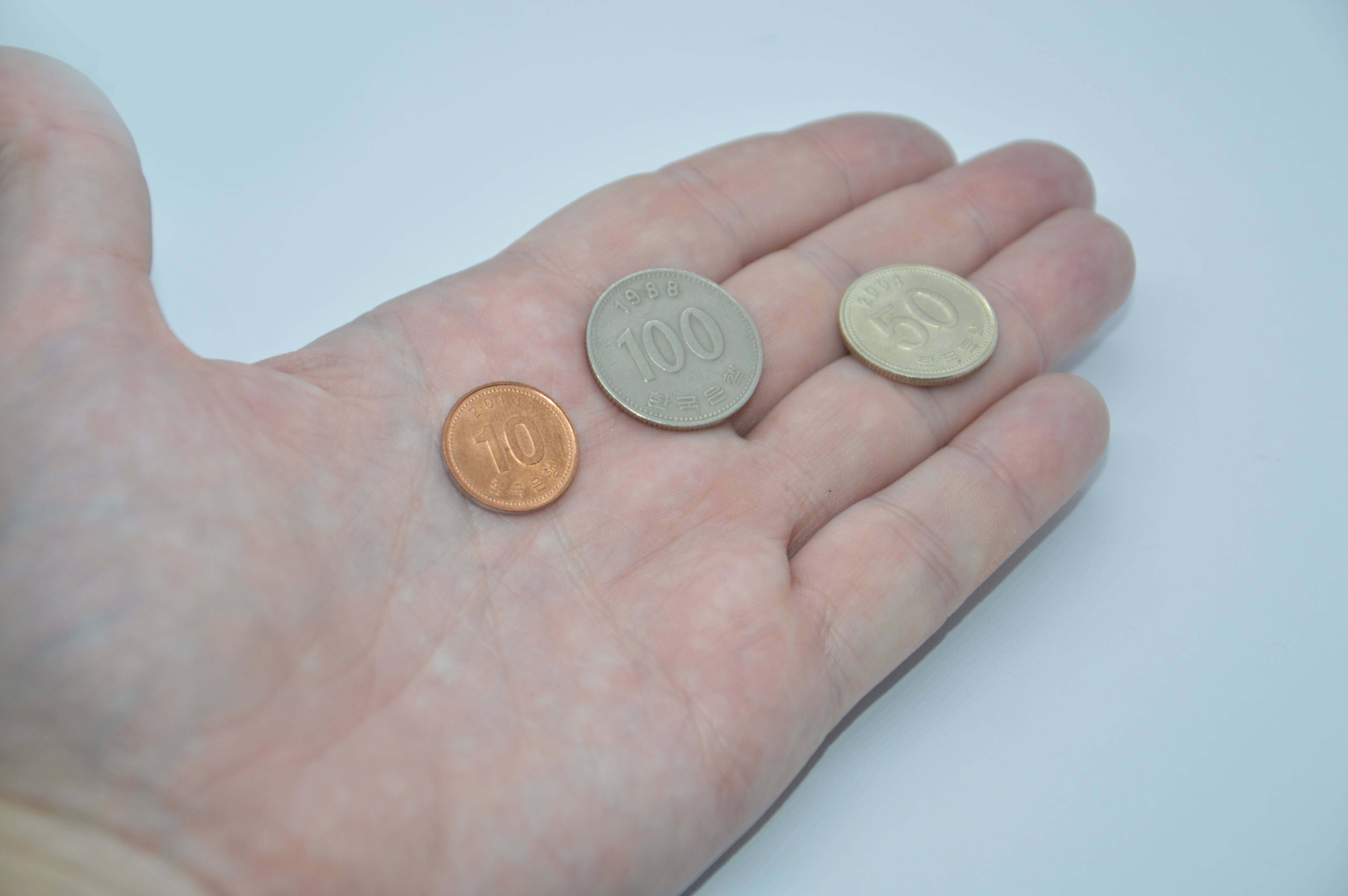 한국 동전을 손에 올려놓음