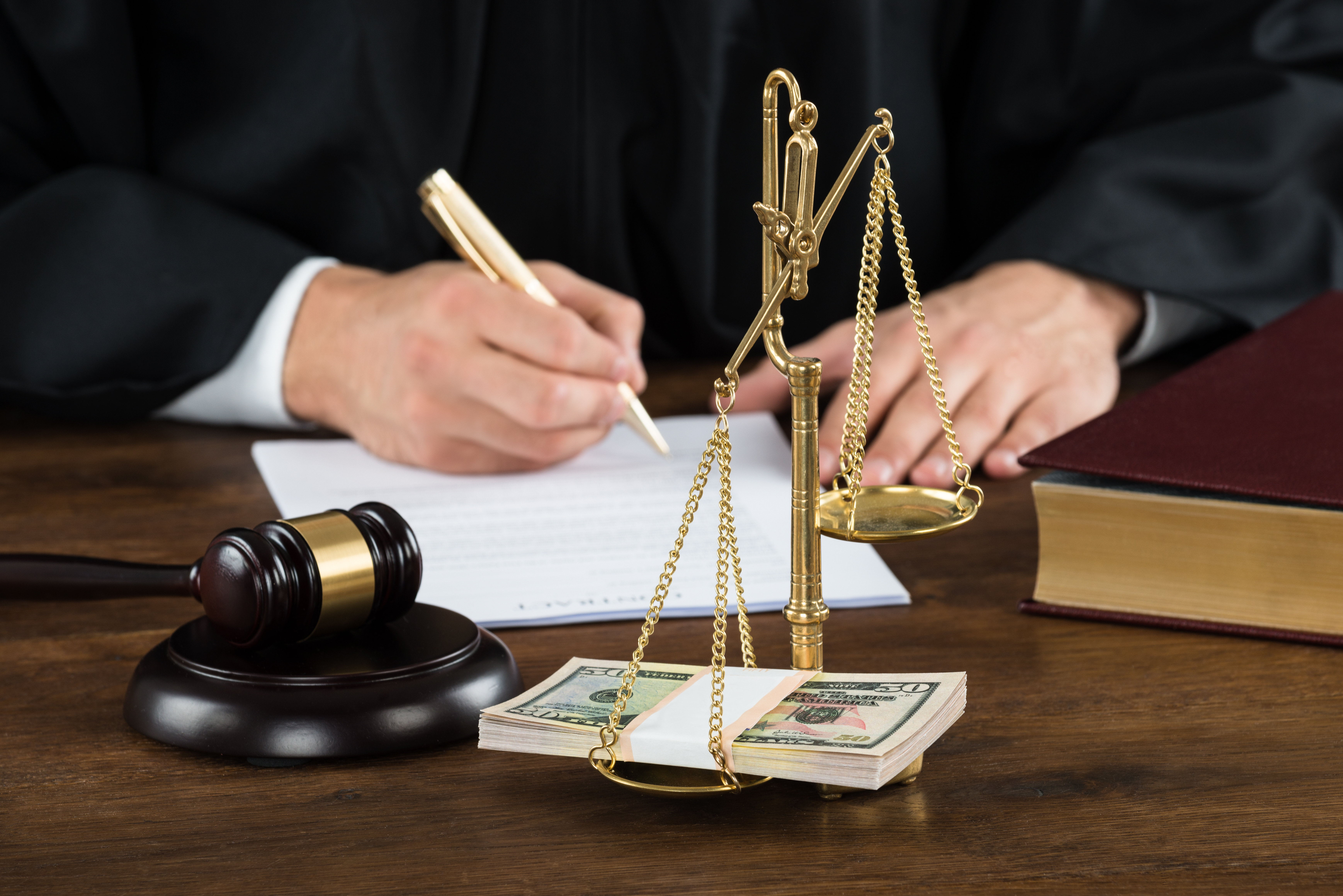 형사 재판에서 금전과 정의를 상징하는 저울과 판사의 서명이 함께 있는 장면, 형사소송 변호사 상담 관련 이미지