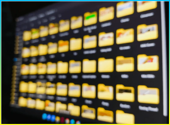 흐릿하게 비친 방에 노트북 화면에 표시되는 Windows 파일 탐색기의 사진.