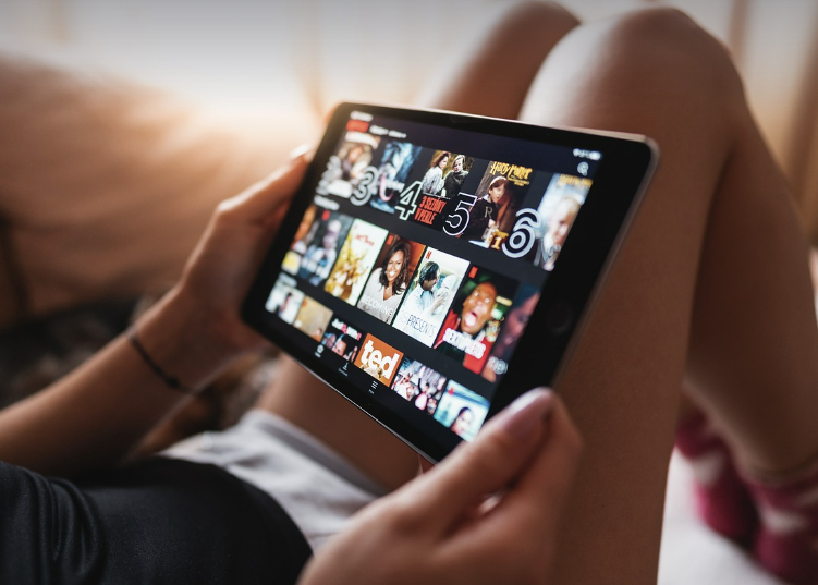 여성이 테블릿으로 어떤 OTT 작품을 볼지 고민하는 사진