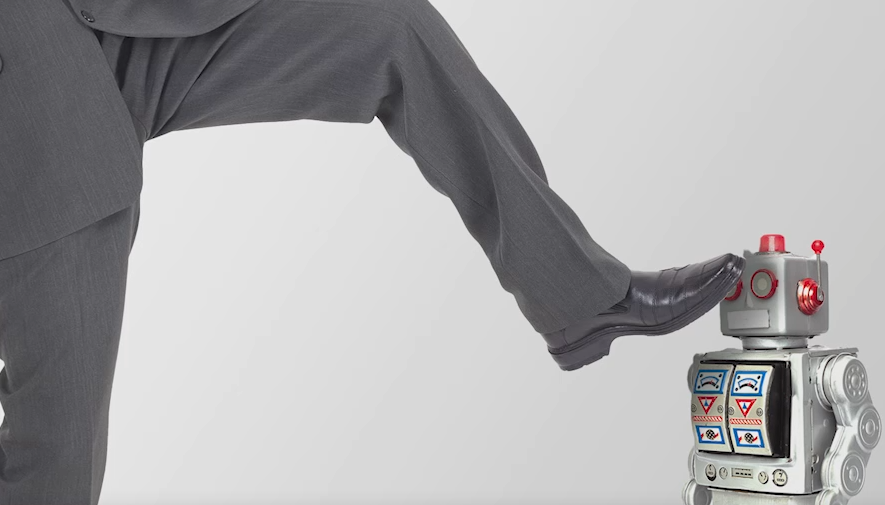 남자가 발로 로봇을 쓰러뜨립니다