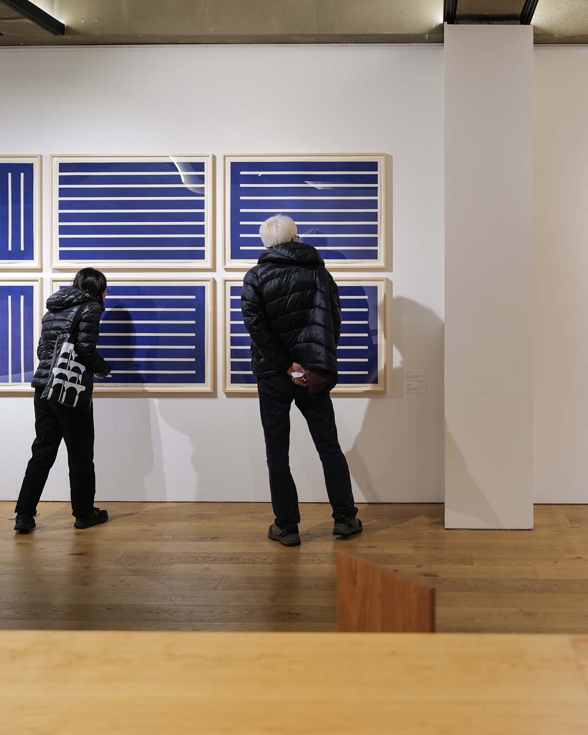 라이카 Q2의 디지털 줌 기능을 활용해 35mm로 크롭한 사진. 어느 한 전시장에서 벽에 걸린 작품을 보고 있는 두 사람이 적당한 배경과 함께 보인다