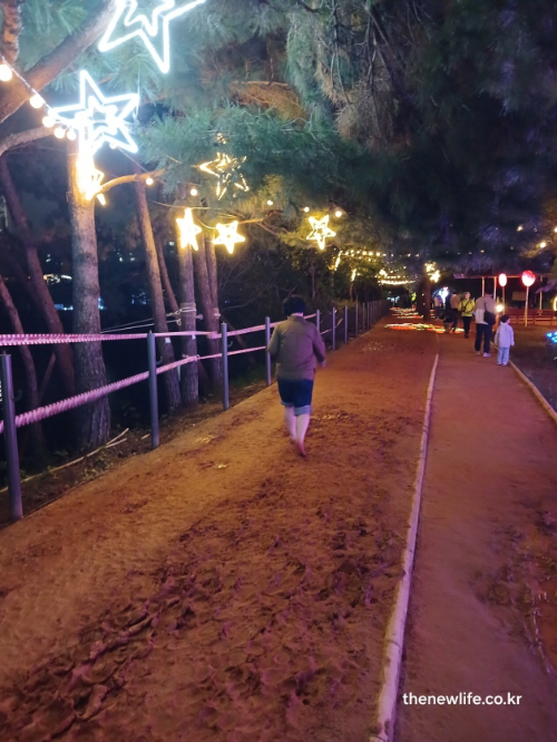 겨울철 장자호수공원에서 야간 조명 아래 황톳(토)길을 맨발로 걷는 모습