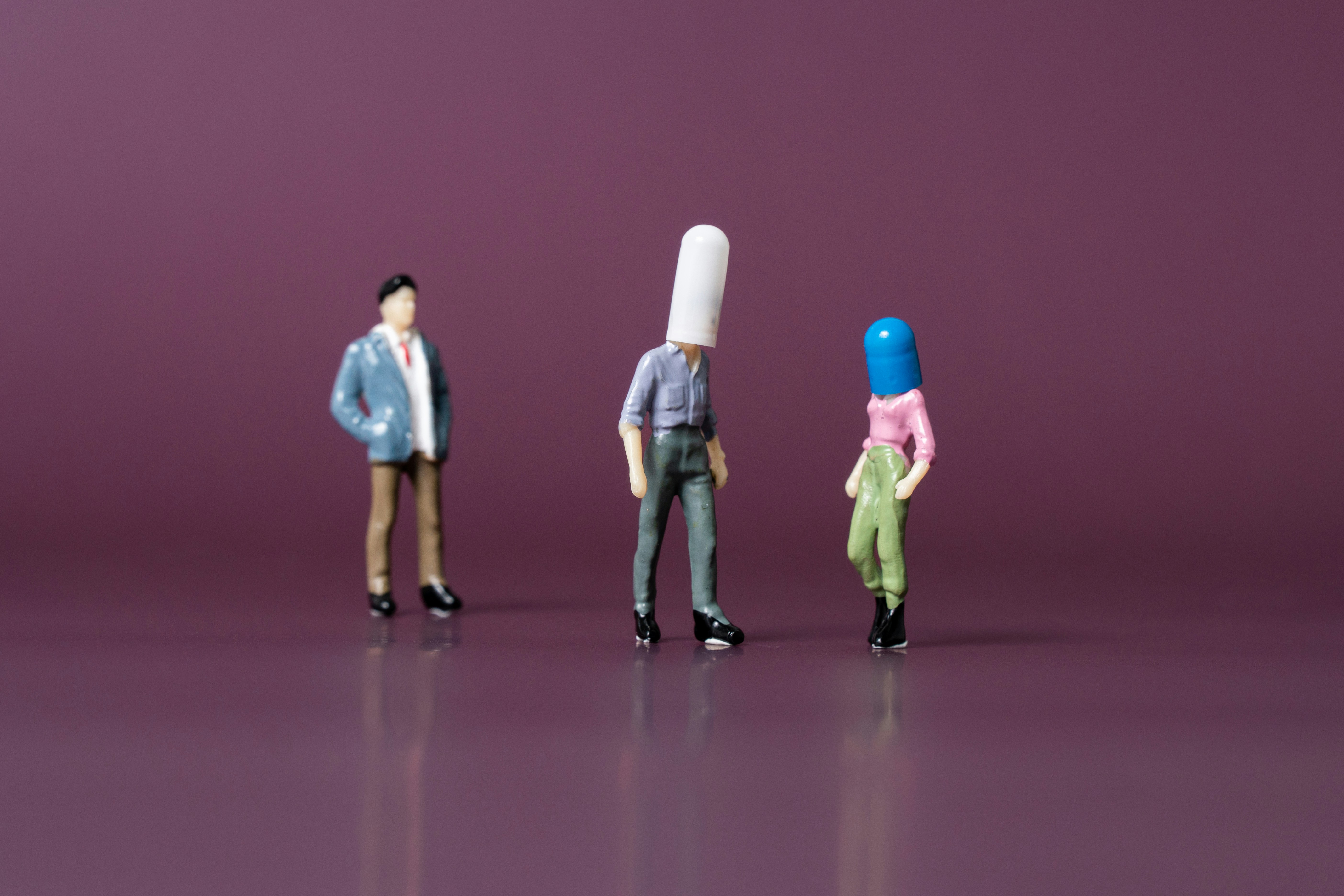 머리에 약 캡슐을 쓴 사람 모형들, 기술 의존과 인간 소외를 상징적으로 표현한 이미지