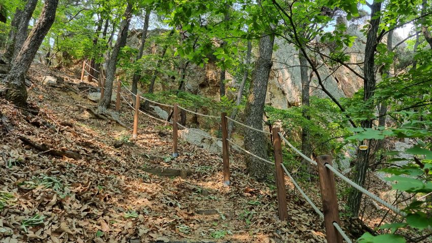 급경사 비탈길에 이중 안전 로프난간, 뒤로는 웅장한 제1봉 바위 절벽,