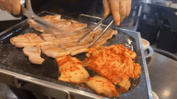 돌판 위에서 삼겹살과 김치를 뒤집고 자르는 모습. 이모님의 능숙한 손놀림이 살아 있는 순간 gif