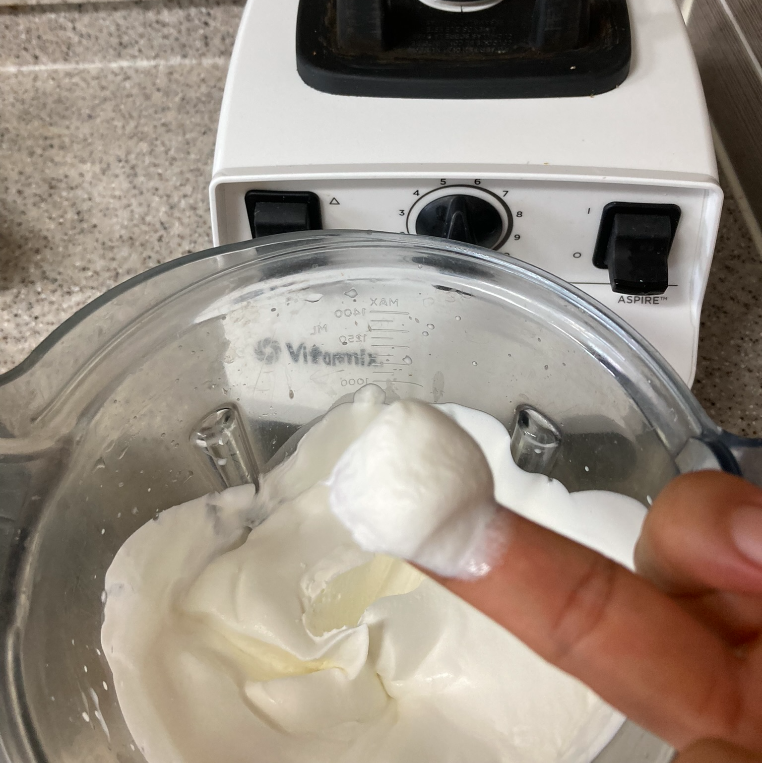 믹서기에서 휘핑된 생크림을 손가락에 올려 맛보는 장면
