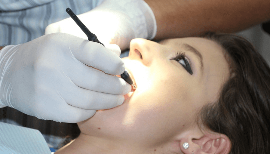 이가 시린 이유로 치과 치료를 받고 있는 여성