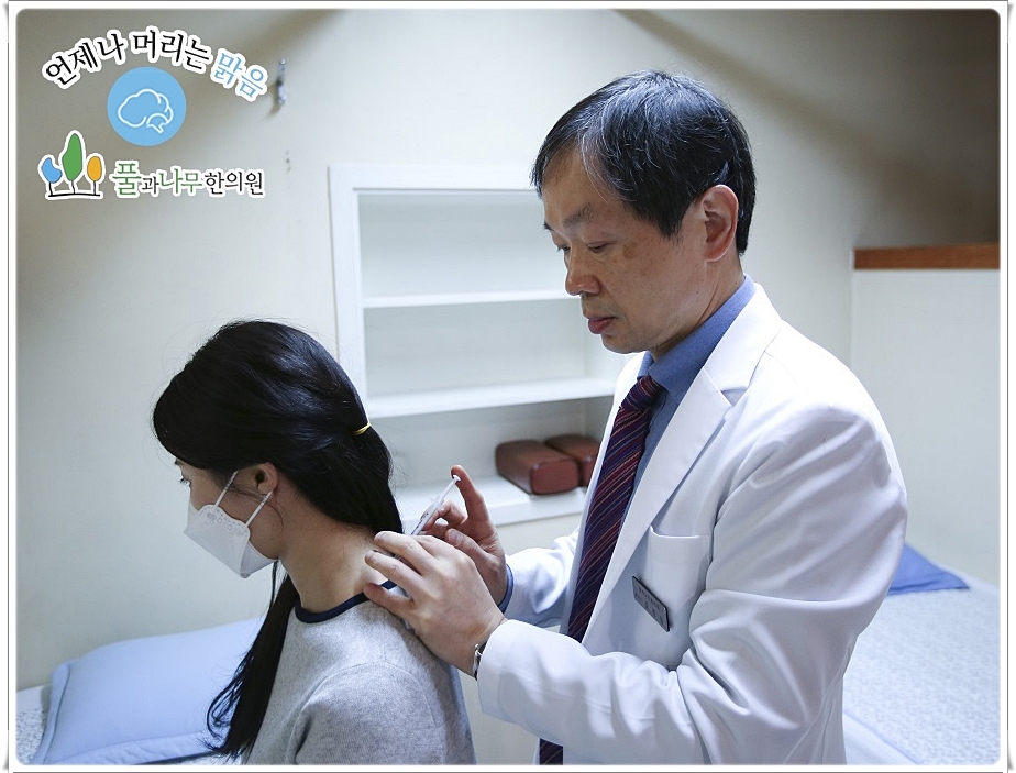 환자의 목 뒤에 약침을 놓고 있는 한의사의 모습