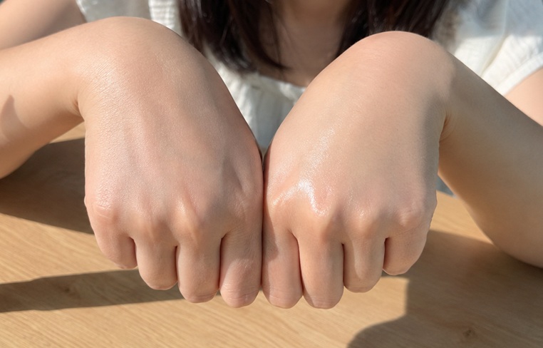 손등 중앙에 흰색 점선을 기준으로 자작나무 수분선크림을 바른 왼쪽의 백탁 현상과 바르지 않은 오른쪽의 피부 톤 비교 사진