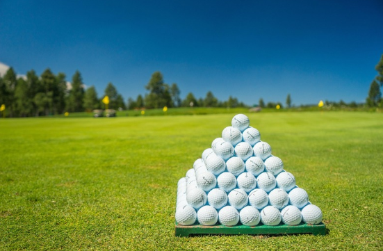 필드에 골프공이 피라미드처럼 쌓아올려 있는 이미지