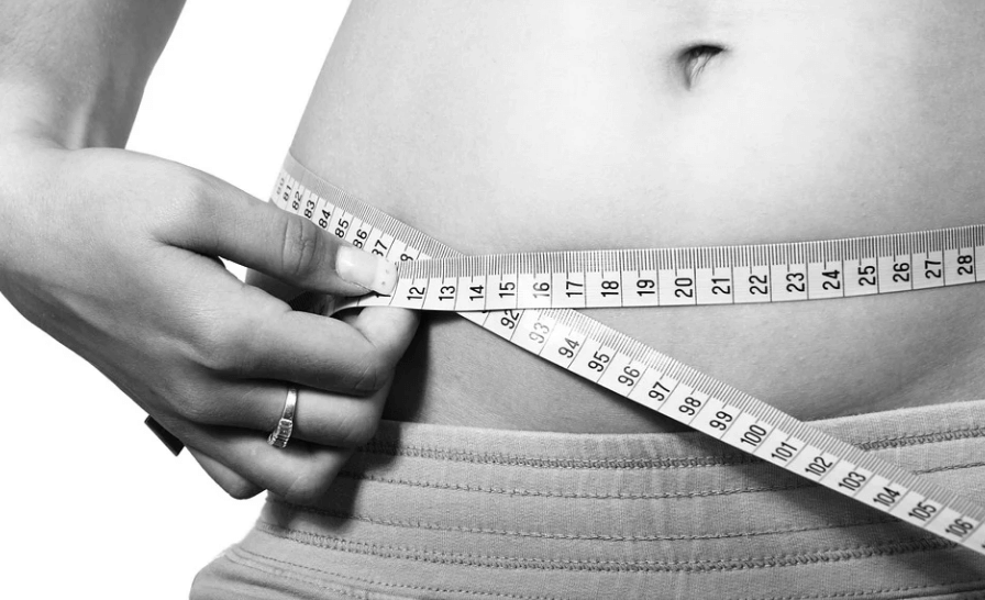 여성이 줄자로 허리 사이즈를 측정하고 있다.