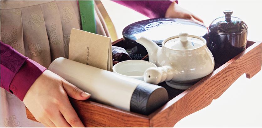 경복궁 생과방 행사에서 맛볼 수 있는 궁중약차 한상. 한복을 입은 여자 1명이 궁중약차 한상을 들고 있음.