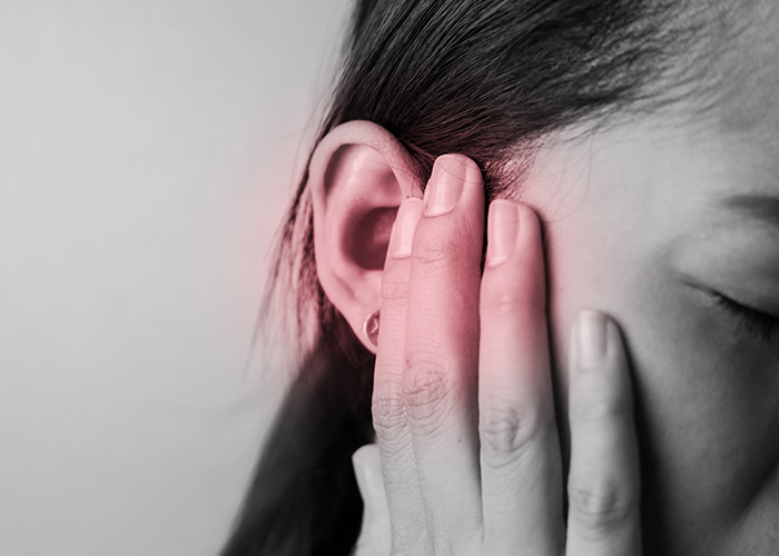 여성이 이석증으로 귀에 손을 대고 있다