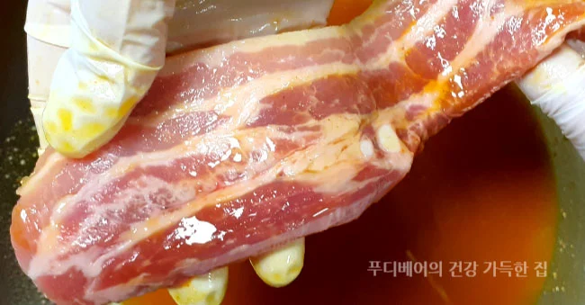 소금-강황-올리브오일로-마리네이드한-삼겹살을-들고있는-모습