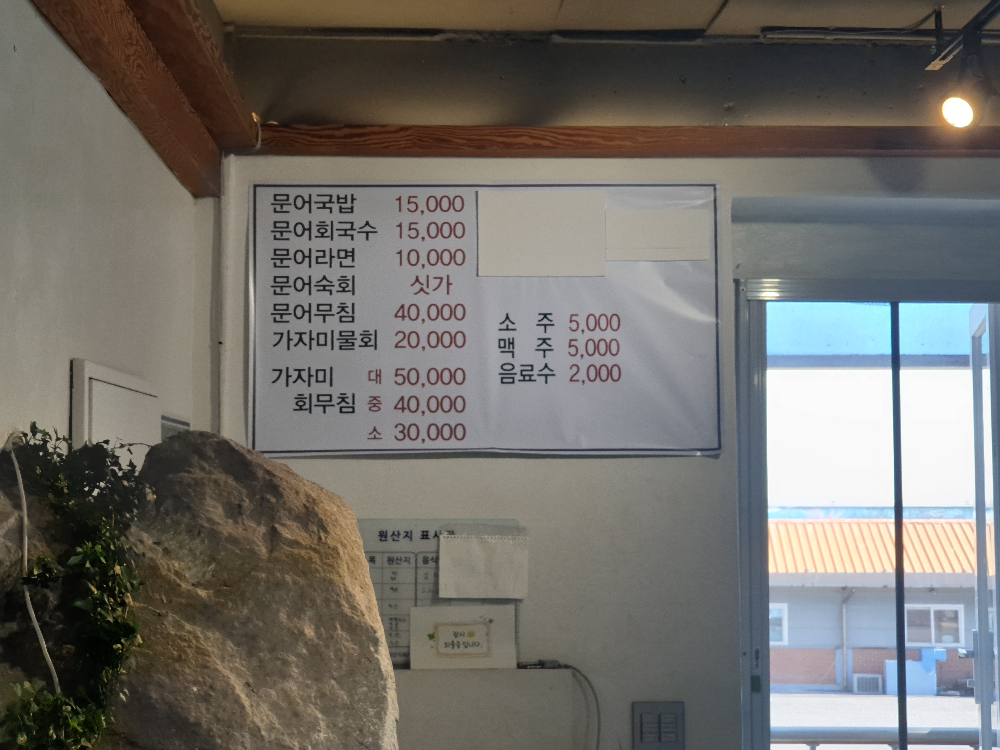 식당 안에 바위가 튀어 나와 있다. 벽에는 메뉴판이 걸려 있다.