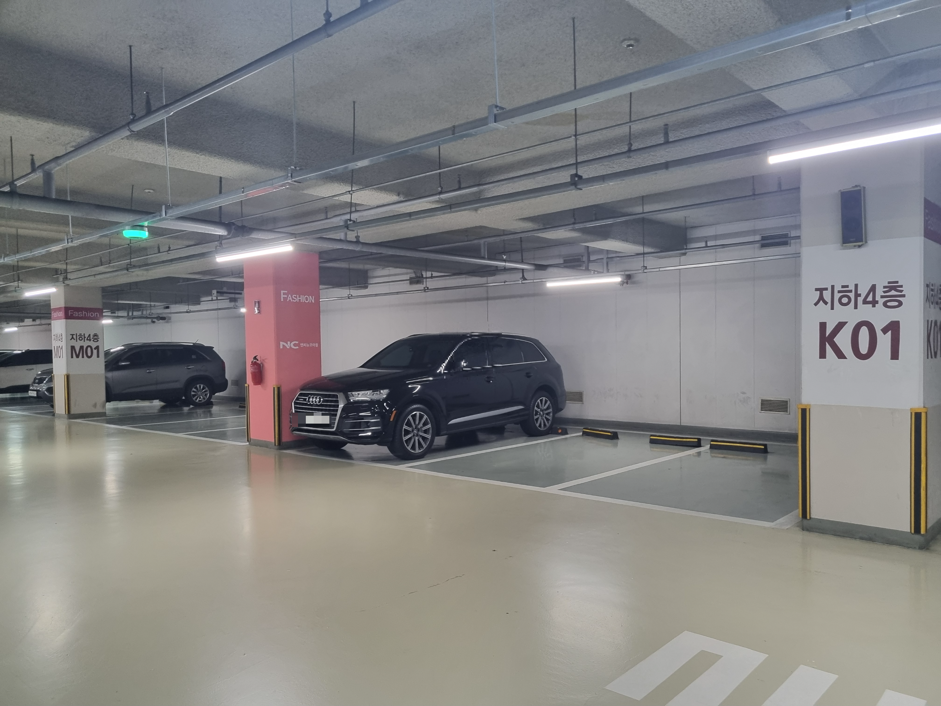 가든파이브 패션관 지하 4층에 주차돼 있는 차량과 영어&amp;#44; 번호가 적혀있는 기둥