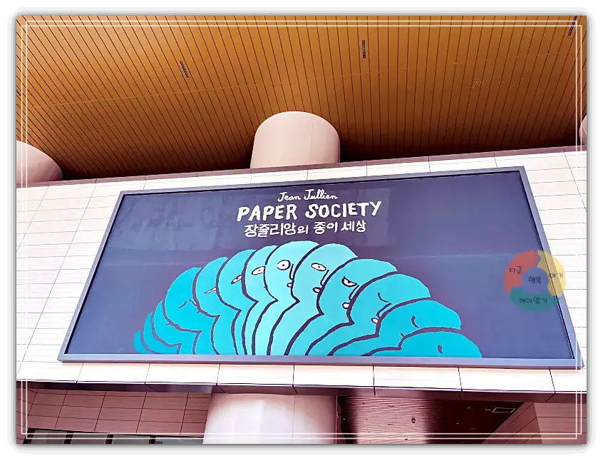 장줄리앙_입구간판-파란색-사람들-반신그림