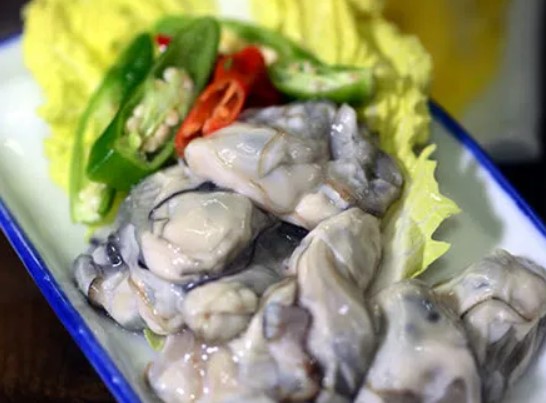 굴이 흰색 접시위에 올려져 있다.