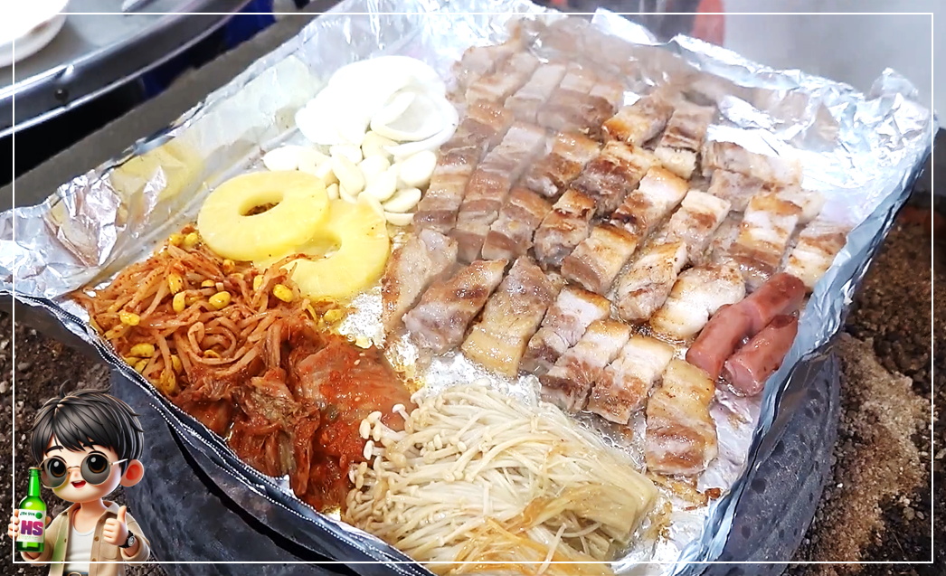 삼겹살과 각종 곁들임용 반찬과 야채 친구들이 장작 난로 위 은박지 호일 불판을 가득 채운 모습