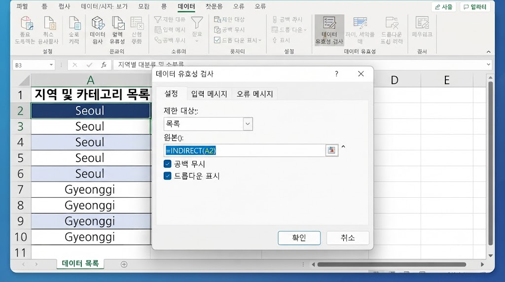 활성화된 엑셀 시트(A열의 'Seoul', 'Gyeonggi' 데이터가 보임) 위에 '데이터 유효성 검사' 대화상자가 열려 있습니다. 대화상자의 '설정' 탭 내 '제한 대상'은 '목록', '원본' 입력란에는 정확히 =INDIRECT(A2) 수식이 입력되어 있으며, '확인' 버튼이 강조된 화면입니다.
