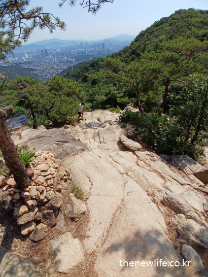 산 정상 부근 바위 구간과 도시 전경 – 마른비만 해결 운동 등산