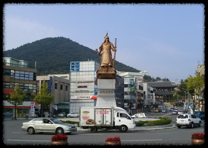 도시 로터리의 중간에 서있는 이순신 장군의 동상 모습